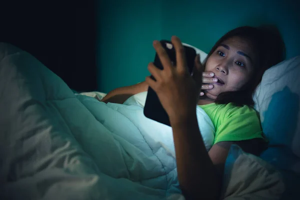 Asian woman play smartphone in the bed at night,Thailand people,Addict social media,Play internet all night,Wow