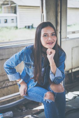 Güzel Asyalı kız iki parmağını tren klasiğinde gösteriyor.
