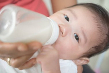 Asyalı bebek sütü şişeden içer, süt zamanı, yatağa git.