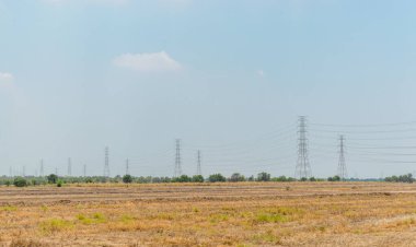 Bulutlu mavi gökyüzü arkaplanındaki elektrik kuleleri  