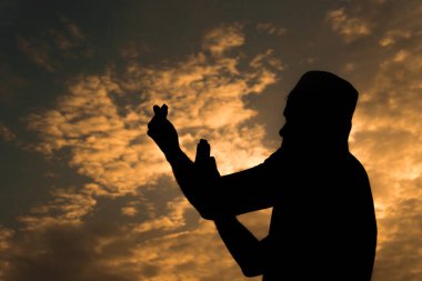 Siluet Genç Asyalı Müslüman adam gün batımında dua ediyor, Ramazan festivali konsepti
