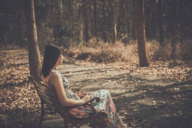 Bankta oturan üzgün kadın, park klasiği tarzında arkadan bakıyor ve hikâyeyi çok daha kötü bir şekilde anlatıyor..