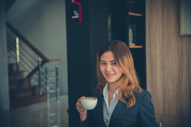 Güzel gülüşlü ofis kızı Yemekten sonra kahve iç