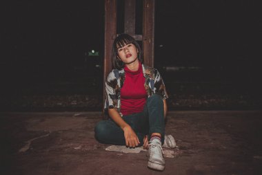 Demiryolunda poz veren Asyalı hippi kız, klasik tarz fotoğraf.