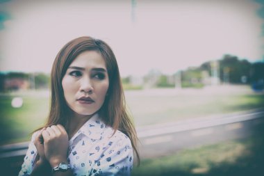 Güzel Asyalı bir kadının dışarıda poz verirken çekilmiş fotoğrafı. 