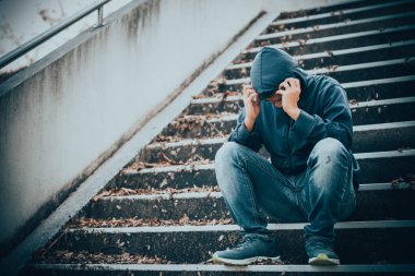 Asyalı üzgün bir adamın portresi, yerde oturan uyuşturucu bağımlısı, flakka ilacı, zombi uyuşturucusu
