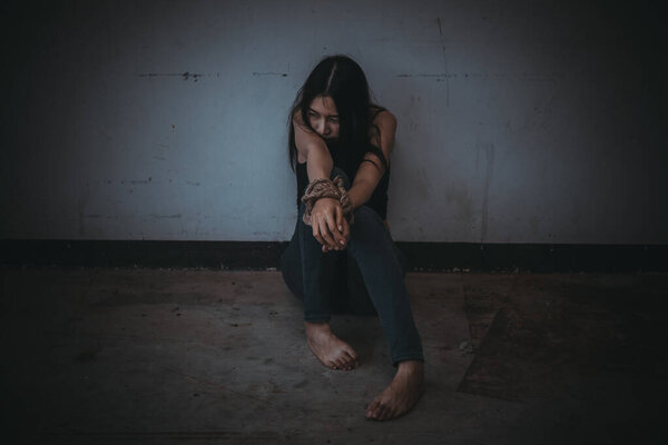 Asian hostage woman Bound with rope at night scene,The thieves kidnapped for ransom,thailand people