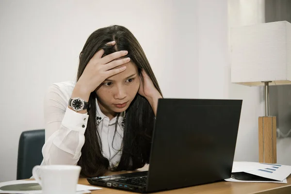 Businesswomanman stress from hard work on the desk at office dark tone,thailand people