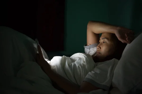 Asian woman play smartphone in the bed at night,Thailand people