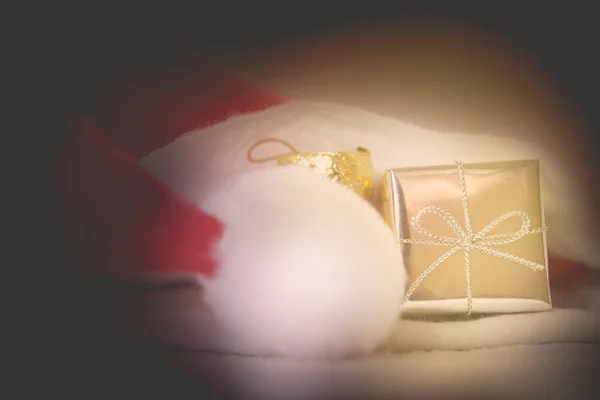 ヴィンテージスタイル ダークトーン ソフトフォーカス 抽象的なクリスマスの背景のためのサンタの帽子とギフトボックス — ストック写真
