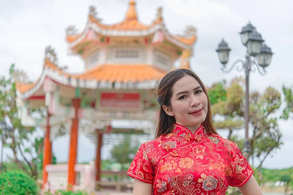 happy Chinese new year. Asian woman wearing traditional Cheongsam clothes  portrait outdoor
