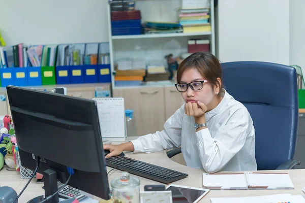Asian businesswoman working on the desk at office,Thailand worker woman smile,Beautiful secretary has a nice smile,Lady clerk overtime time at the company.