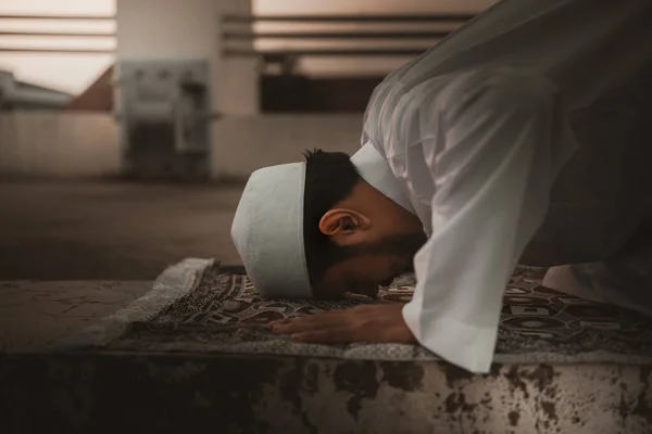 一个年轻的亚洲穆斯林男子在夕阳西下祈祷斋月 — 图库照片