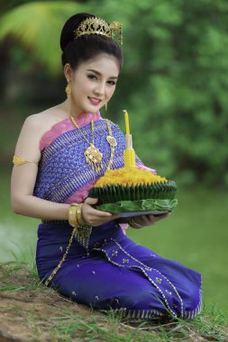 Tayland elbisesi içindeki güzel Asyalı kadın portresi geleneksel dua Kratong 'u, Tayland' da düzenlenen loy kratong festivaline katılması için tutuyor.