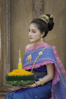 Portrait of beautiful asian woman in Thai dress traditional praying hold kratong for join loy kratong festival at thailand clipart