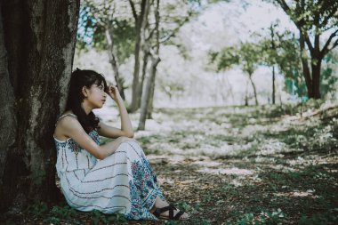 Asyalı, üzgün, güzel bir kadın. Gereksiz aşktan. Sevgilisi hakkında çok şey düşünüyor.