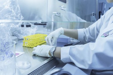 Bilim adamı deneyden önce kimyasalları sallama makinesiyle karıştırdı. Laboratuvarda çalışan Tayland 'lı bilim adamı test tüplerine numuneler karıştırdı.