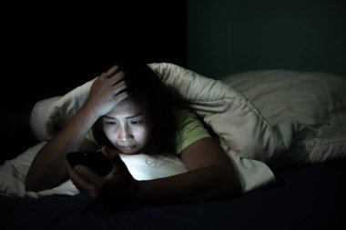 Asyalı kadın gece yatakta akıllı telefon çalar, Taylandlılar...