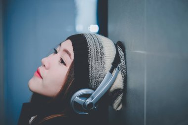 Güzel Asyalı kadın kulaklıkla müzik dinle, modern kadının yaşam tarzı.
