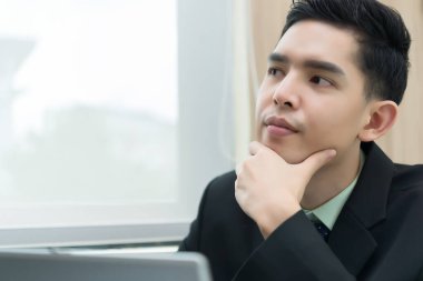 Asyalı işadamı ofiste çalışmayı düşünüyor, Tayland işçisi yarın için bir proje düşünüyor.