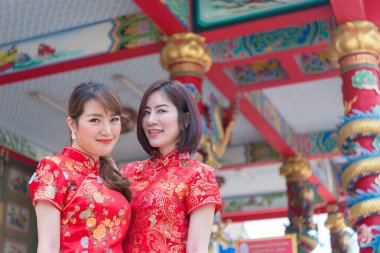 Cheongsam elbiseli iki güzel Asyalı kadının portresi, Tayland halkı, mutlu Çin yeni yılı konsepti.