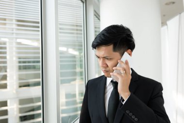 Asyalı işadamı CEO şirketiyle iş hakkında telefonda konuştu.
