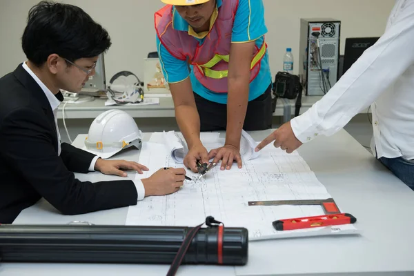 三位亚洲工程师看了大楼的平面图 讨论了办公室建设的问题和解决方案 客户投诉工程师没有按时发送绿色大楼 — 图库照片