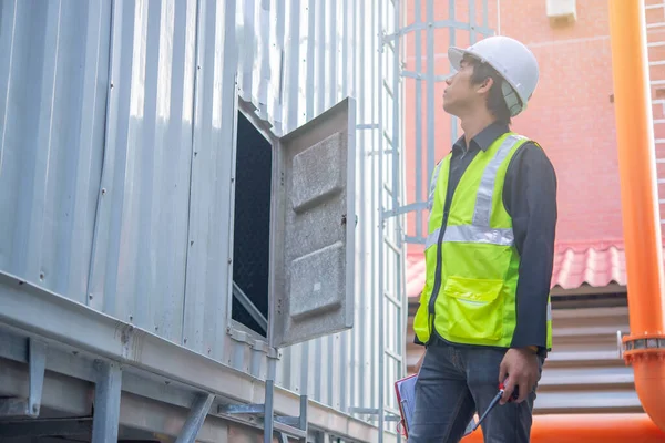 Asian Maintenance engineer at the waste water management system of a huge factory,maintenance checking technical data of heating system equipment,Thailand people