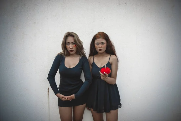 两个性感的姑娘穿着黑色衣服站在白墙的中间 从后面 深色调 黑色和白色 深色的概念 — 图库照片