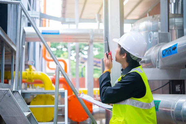 Asian Maintenance engineer at the waste water management system of a huge factory,maintenance checking technical data of heating system equipment,Thailand people