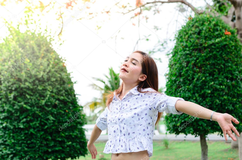 Beautiful woman smiling outdoors with bright sunlight on background