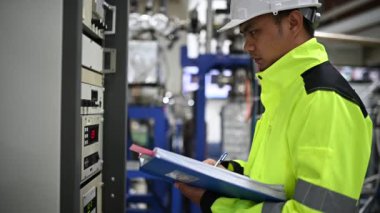 Elektrik mühendisi kontrol odasındaki güç dağıtım dolabındaki voltajı kontrol ediyor.