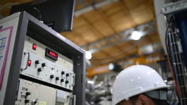 Elektrik mühendisi kontrol odasındaki güç dağıtım dolabındaki voltajı kontrol ediyor.