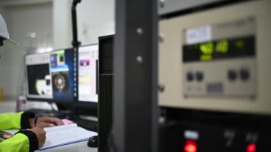 Elektrik mühendisi kontrol odasındaki güç dağıtım dolabındaki voltajı kontrol ediyor.