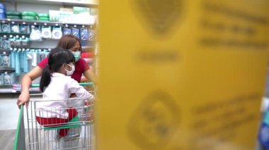 Anne ve tatlı kız süpermarkette ürün seçiyorlar. 