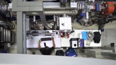 Fabrikada bilgisayarla çalışan bir adamın en üst görüntüsü