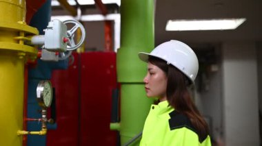 Operasyon salonunda çalışan miğferli Asyalı kadın mühendis.