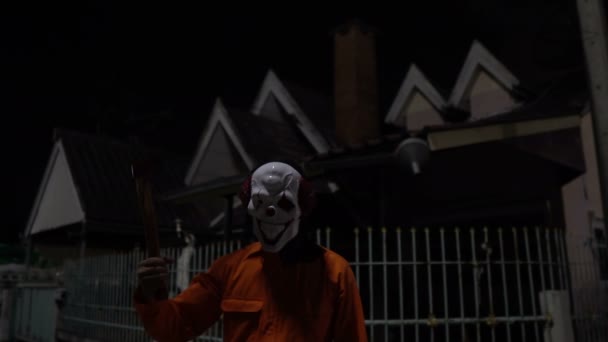亚洲男人带着小丑面具 晚上拿着武器 万圣节的概念 恐怖的橙色衣服杀手的照片 — 图库视频影像
