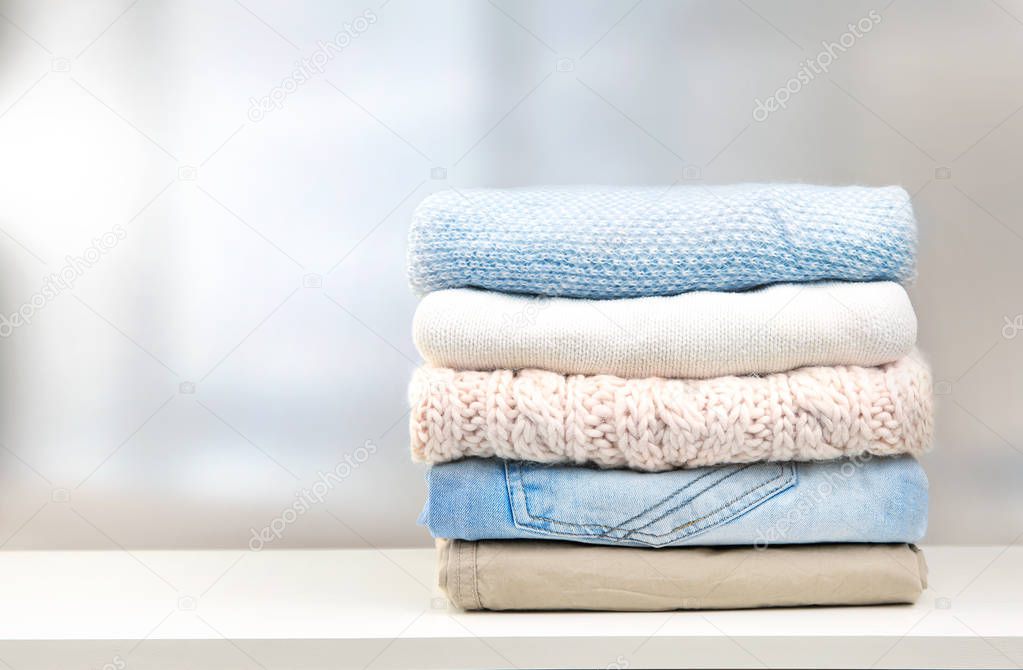 Stack of clothes on  table empty space background.