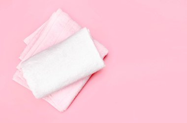 Pembe boş alan arka planda katlanmış havlular.