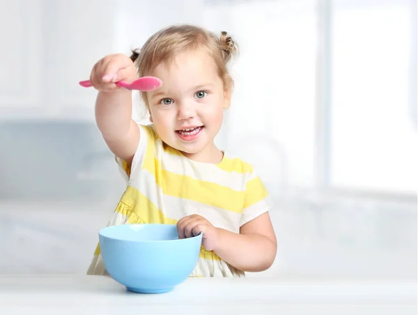 Barn med sked och skål, flicka äter. Barnens näring. — Stockfoto