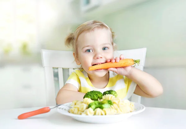 Kislány eszik sárgarépa, zöldségek, egészséges étkezés. Gyermek diórét — Stock Fotó