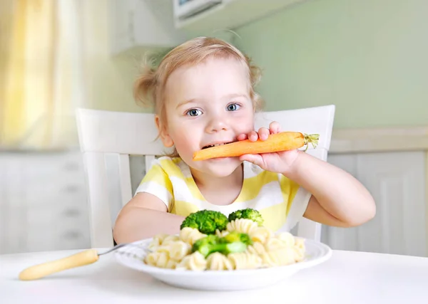 Kislány eszik sárgarépa, zöldségek, egészséges étkezés. Gyermek diórét — Stock Fotó