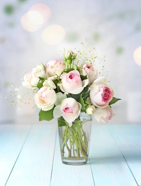 Buquê de flores de rosas em vaso na mesa de madeira . — Fotografia de Stock