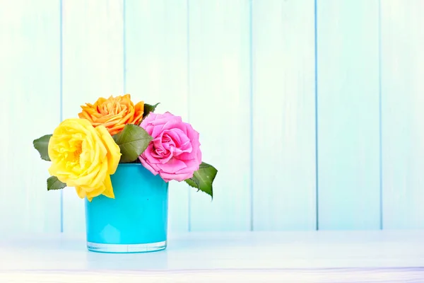 Rose flowers bouquet in vase on blue wooden background. — Stock Photo, Image