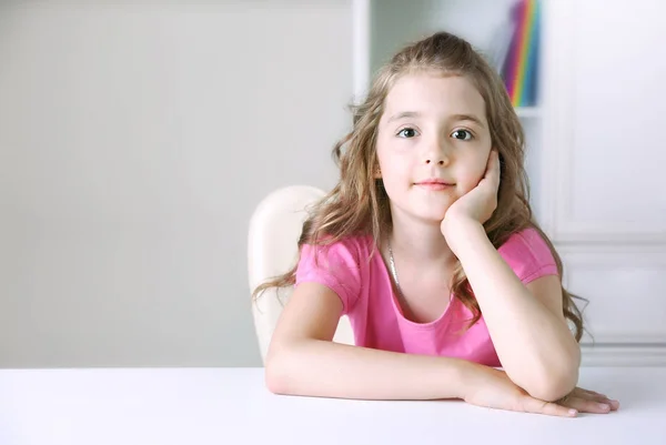 Child girl sitting at desk empty space background. — Stock Photo, Image