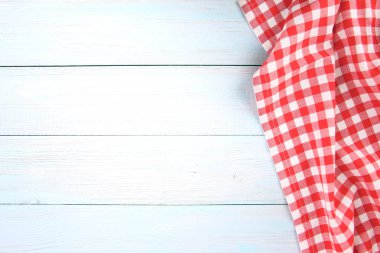 Kırmızı, piknik havlusunu mavi ahşap boş alanda kontrol etti.