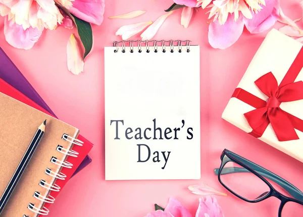 Teachers day holiday greeting card.Teacher\'s day backdrop.pink flowers,book stack,gift box,glasses.