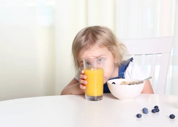 Çocuk Yemeğini Yer Çocuk Bir Bardak Portakal Suyunun Arkasına Saklanır — Stok fotoğraf