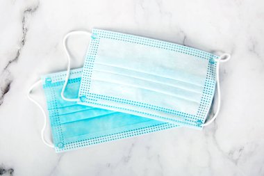 Yüz maskesi üst görüntü. Masada koruyucu mavi tıbbi maskeler. Kapalı koruma..